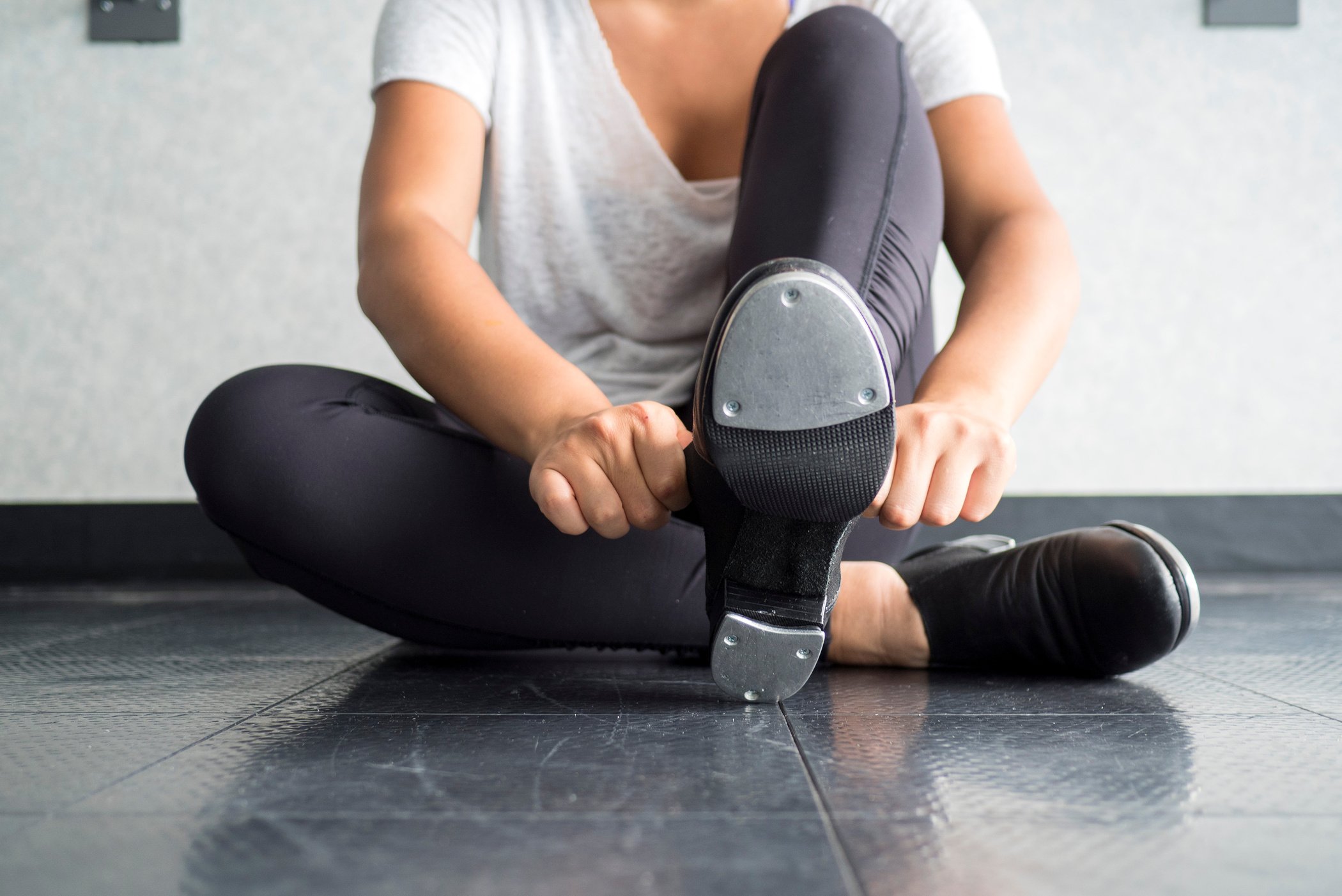 Tap dancer sliding on her tap shoes in the dance studio during dance class